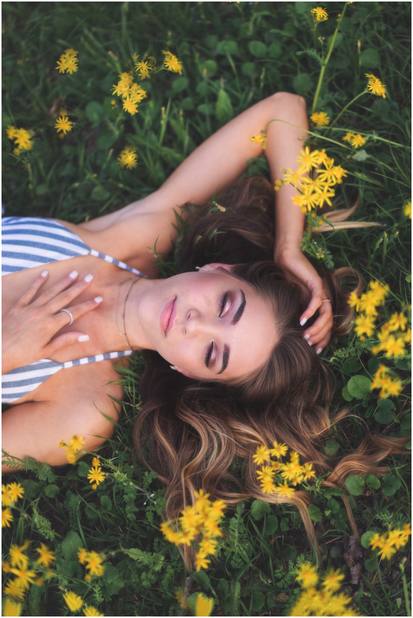 beautiful girl laying in a field of yellow flowers